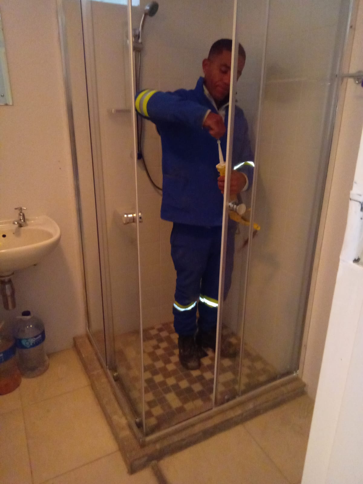 Chasea plumber sealing a shower enclosure